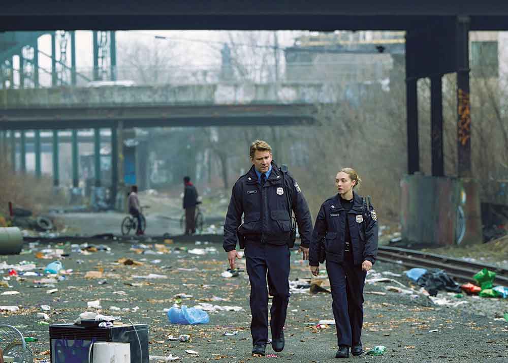 Long Bright River on USA Network. Pictured: Dash Mihok as Eddie and Amanda Seyfried as Mickey, in a street scene in Philadelphia.