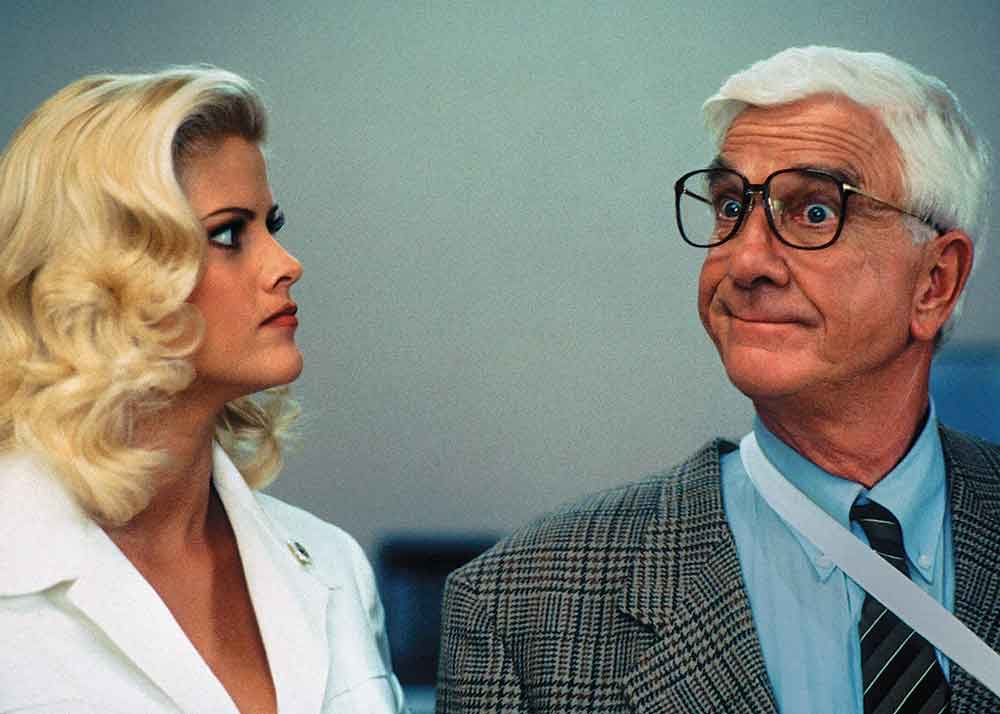 The Naked Gun 33 1/3: The Final Insult on Pluto TV’s Summer of Movies Channel. Pictured: Anna Nicole Smith and Leslie Nielsen in a scene from the final Naked Gun sequel.