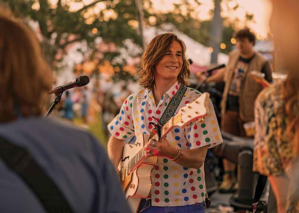 The Runarounds on Prime Video. Pictured: Axel Ellis portrays band member Neil.