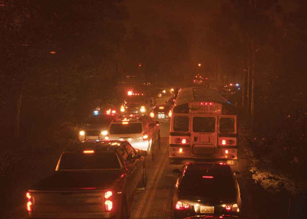 The Lost Bus on Apple TV+. Pictured: People in vehicles trying to escape the extreme conditions of a wildfire.