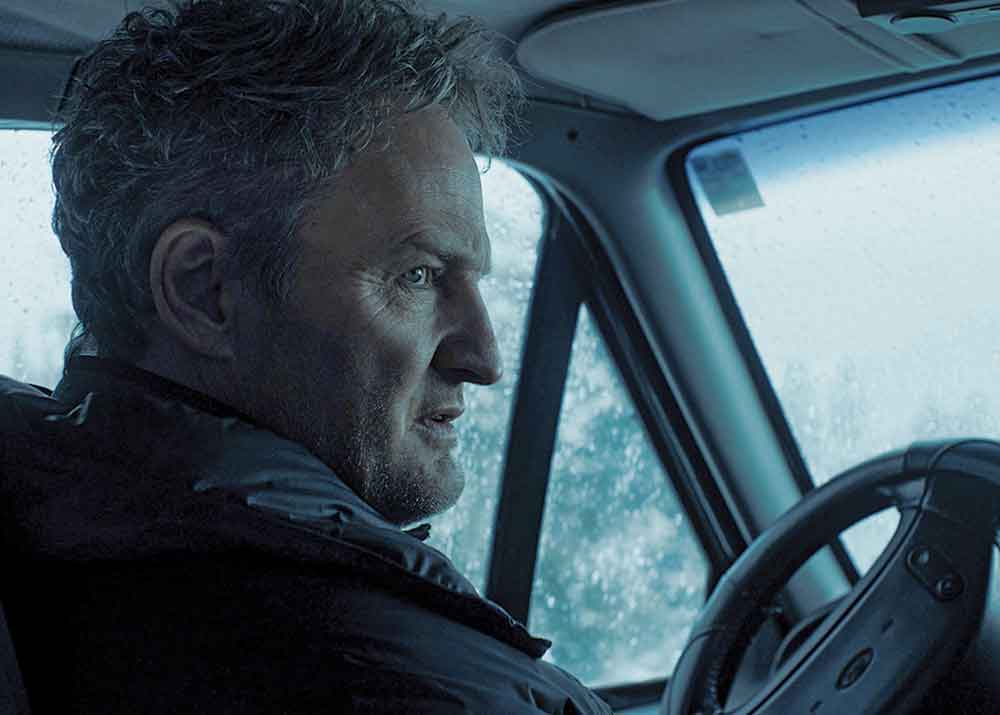The Last Frontier on Apple TV. Pictured: When the jurisdiction of a lone U.S. Marshal (Jason Clarke) is turned upside down after a prison transport plane crashes in the remote wilderness, setting free dozens of violent inmates, he begins to suspect the crash was not an accident.